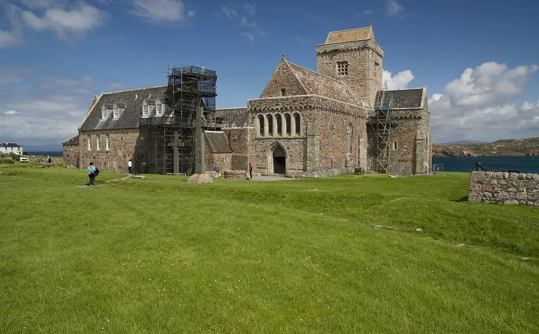 La Iona Abbey in pietra grigia, circondata dal prato verde dell'isola